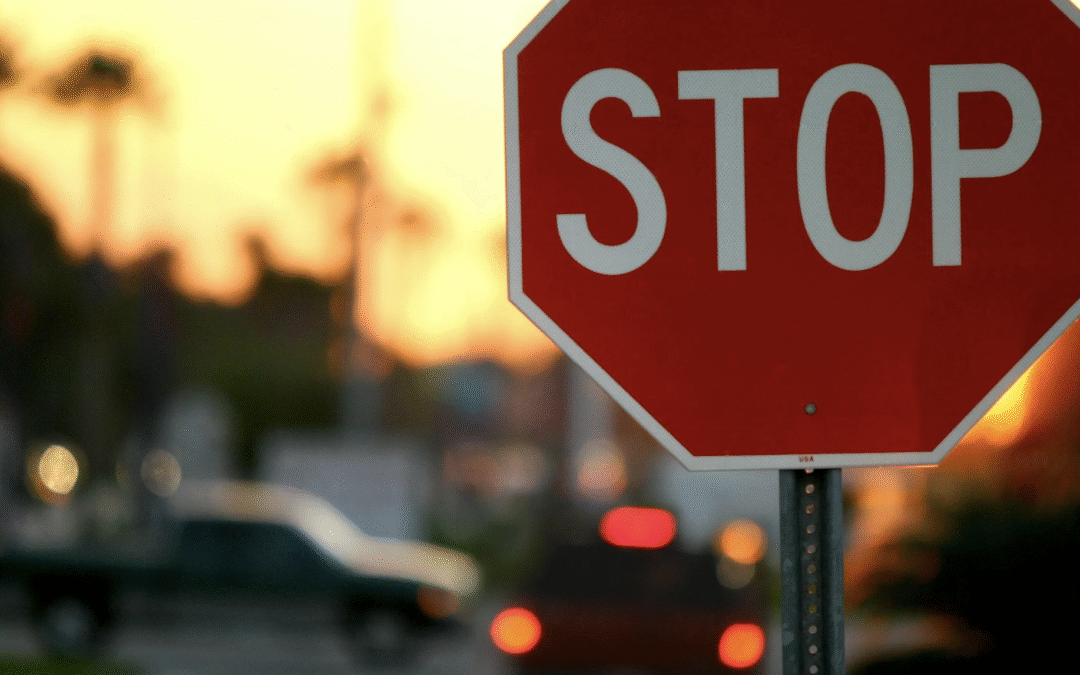 Busy street with stop sign at sunset
